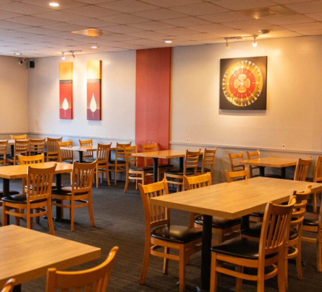 Thai restaurant San Jose, CA dining area with wooden tables and Thai wall art at Red Chili